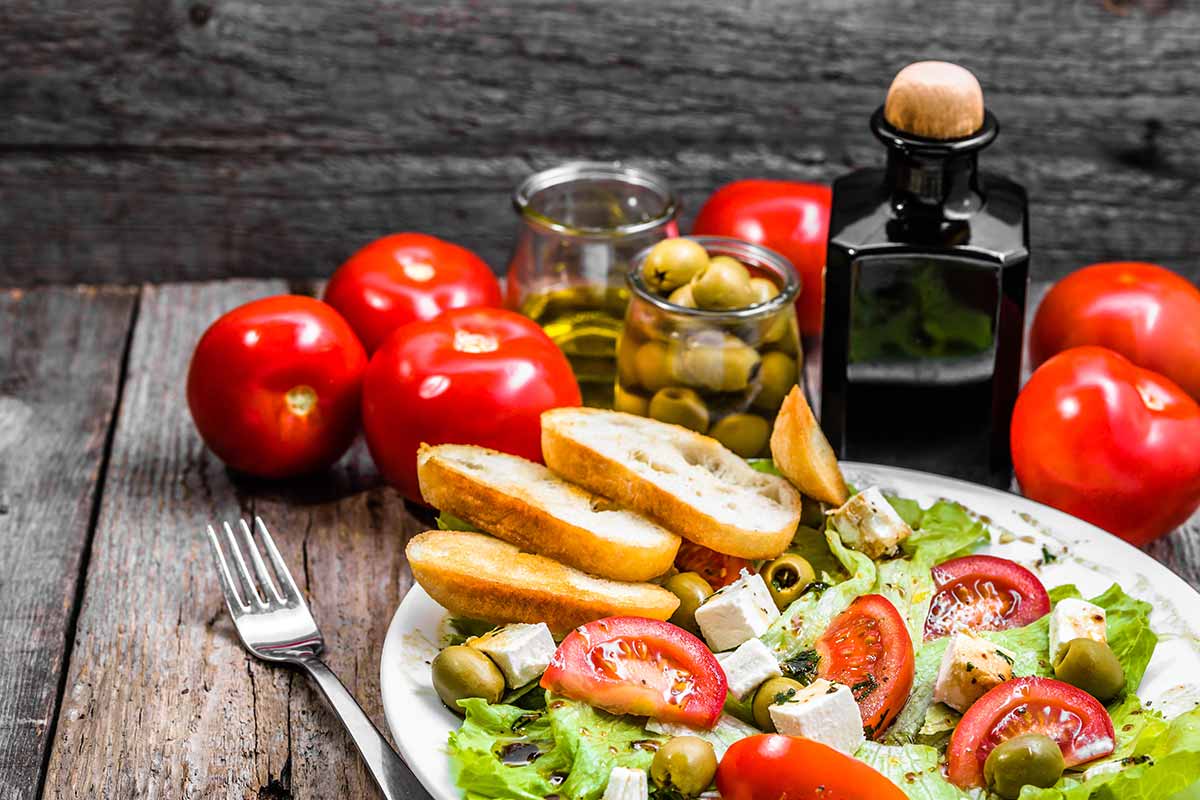 Piatto con pomodori, pane olio e alimenti tipici della dieta mediterranea