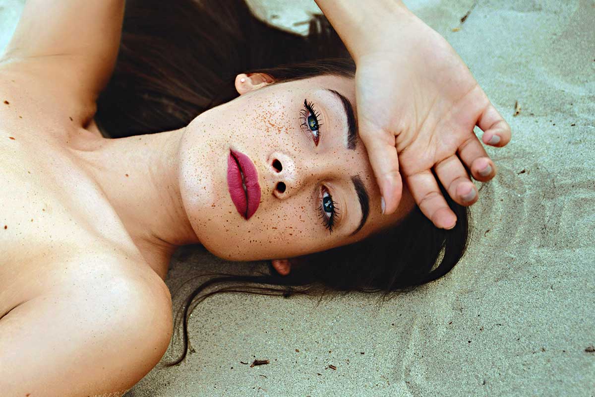 ragazza sdraiata su sabbia