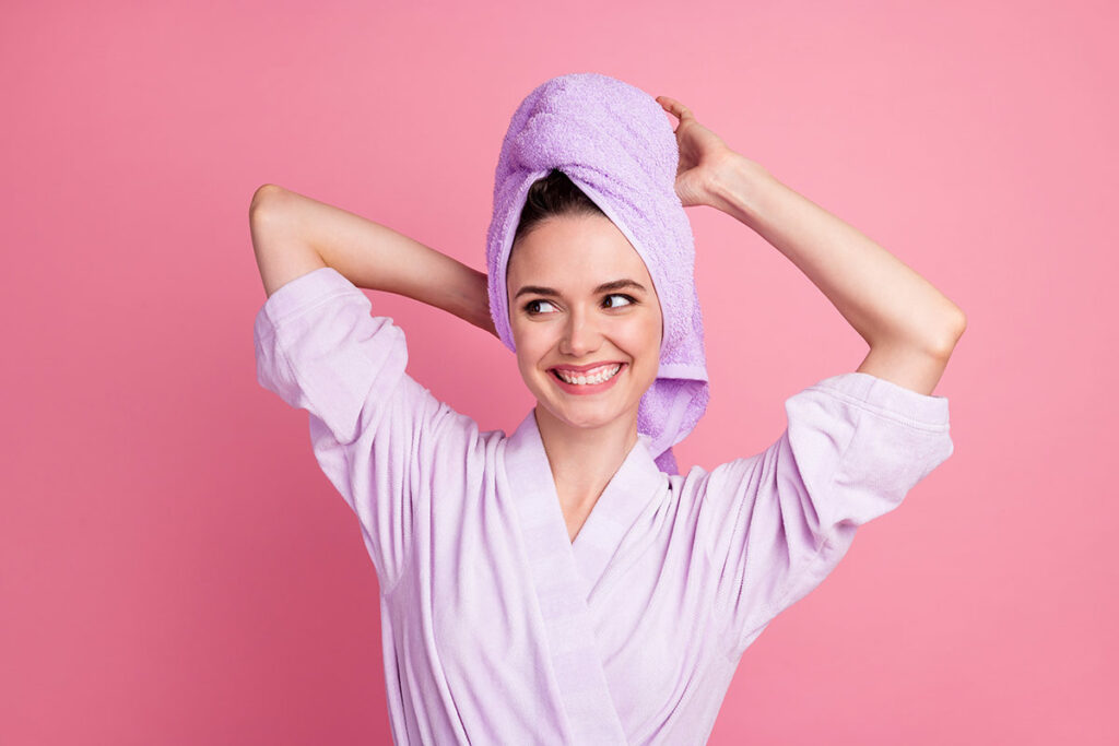 ragazza con asciugamano nei capelli post shampoo-come prendersi cura dei capelli grassi