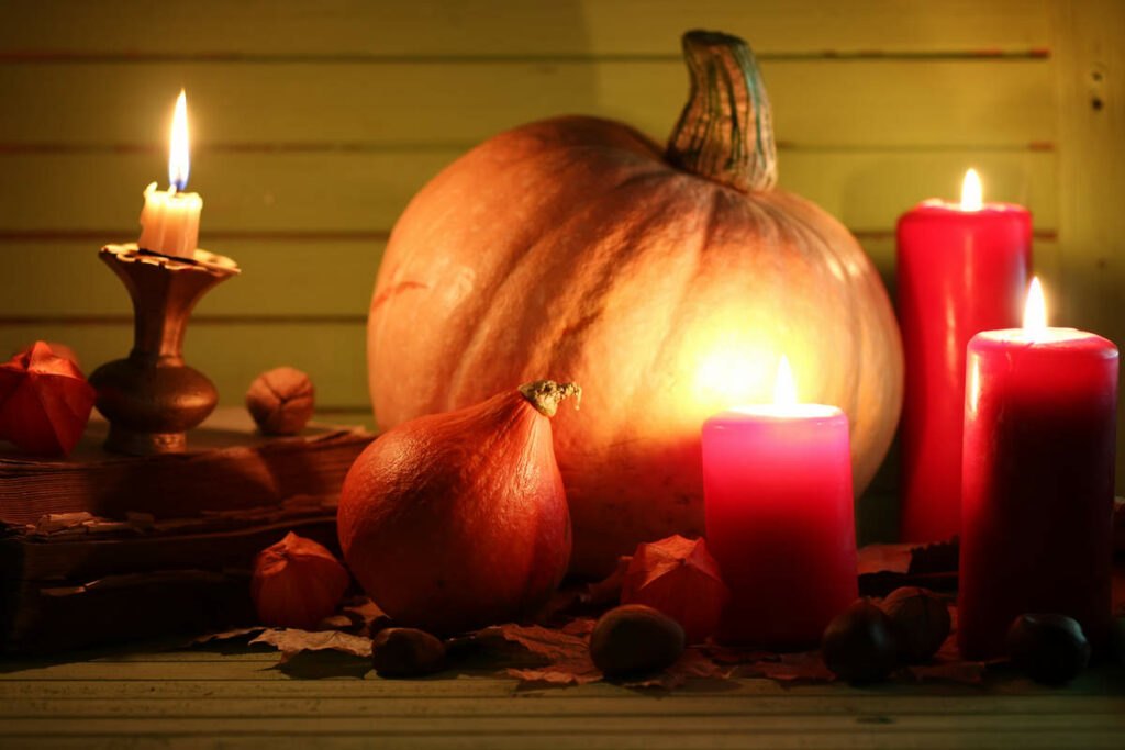 composizione con zucca di halloween e candele di colore rosso