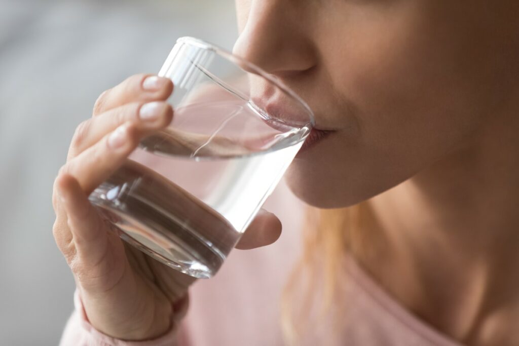 primo piano donna che beve bicchiere d'acqua 