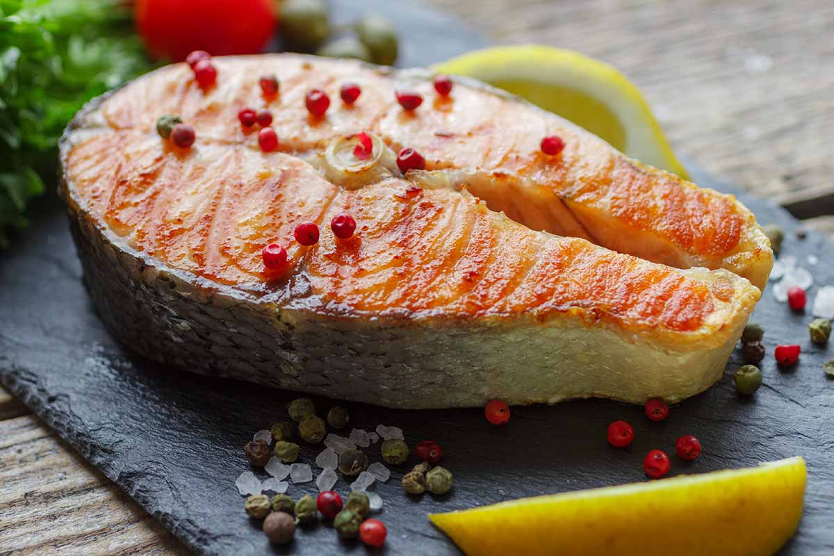 Trancio di salmone con pepe rosa su piatto di ardesia