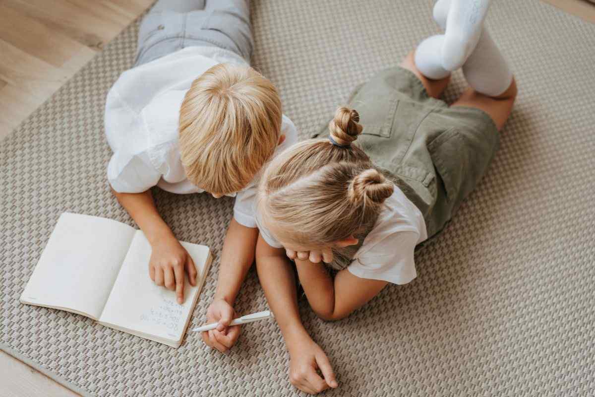 bambini sul tappeto che fanno i compiti