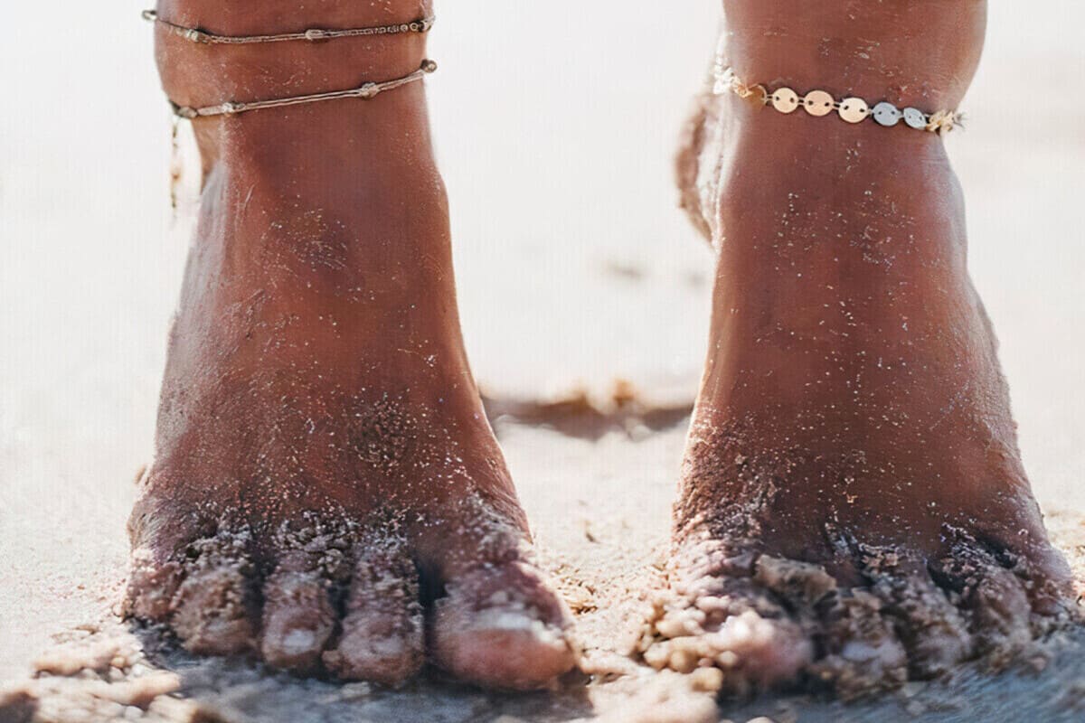 Foto piedi nella sabbia con cavigliere
