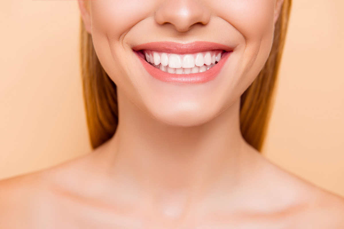 volto di ragazza a metà con sorriso e denti bianchi