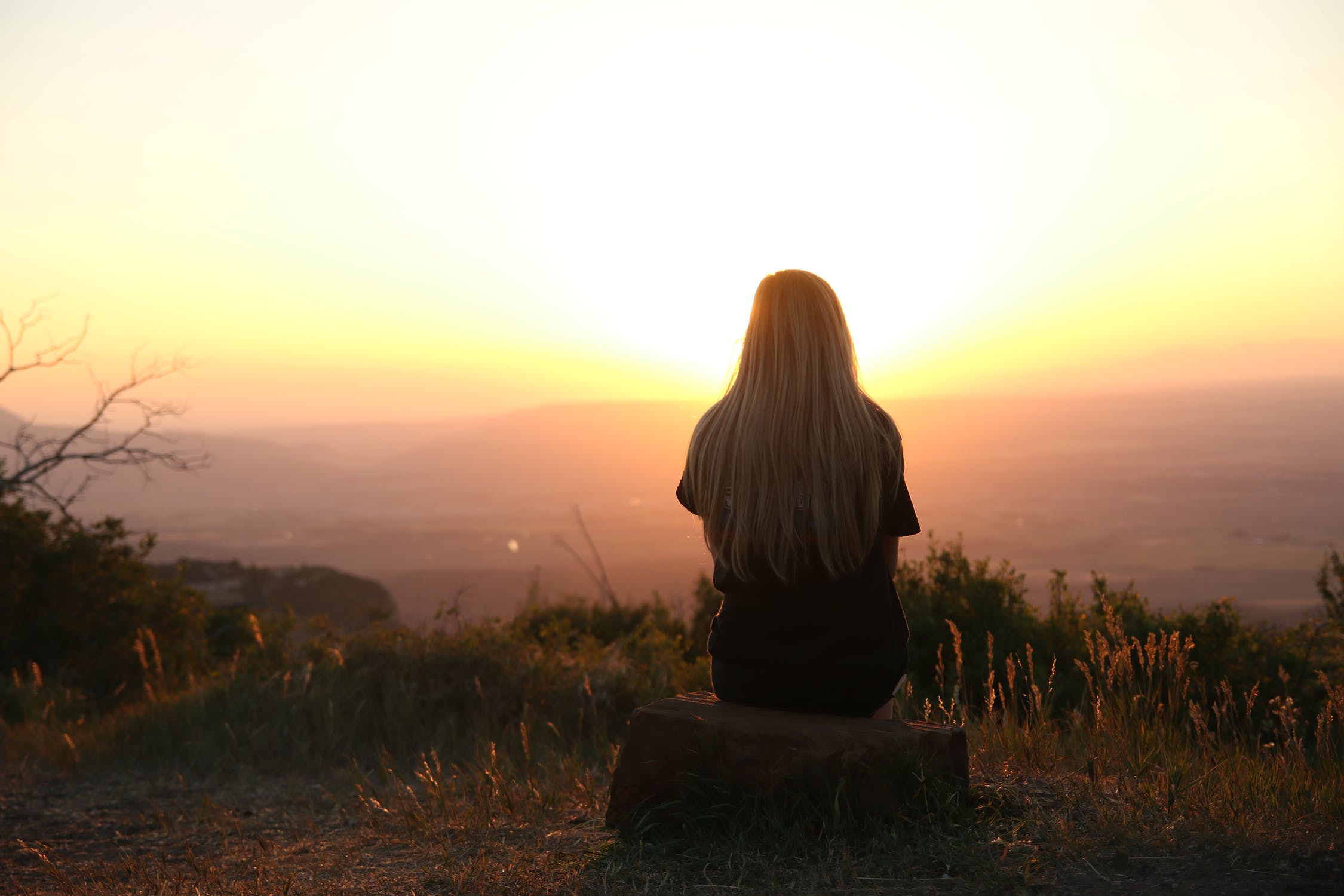 ragazza guarda il tramonto da sola