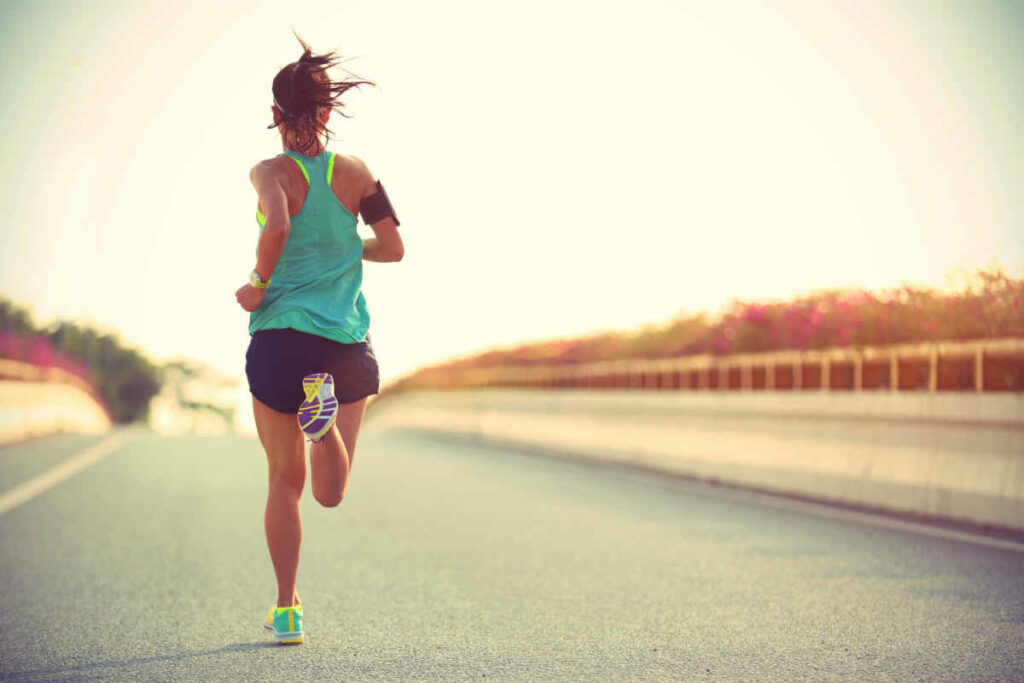 donna di spalle che sta correndo con abiti sportivi