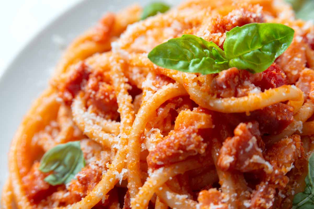 Piatto di bucatini all'amatriciana con foglia di basilico