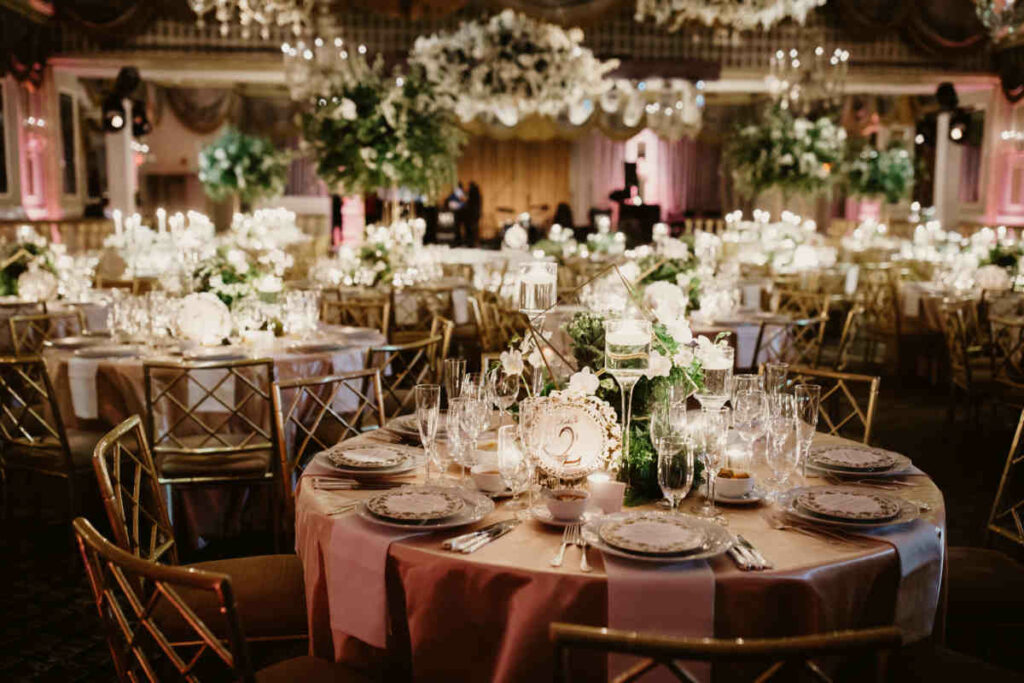 tavoli decorati con fiori, piatti e bicchieri per un ricevimento di matrimonio  