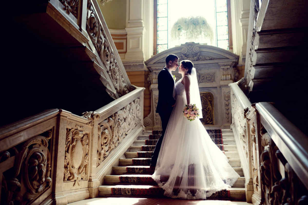 coppia uomo e donna abbracciati su una scalinata nel loro giorno del matrimonio, con abiti da sposi