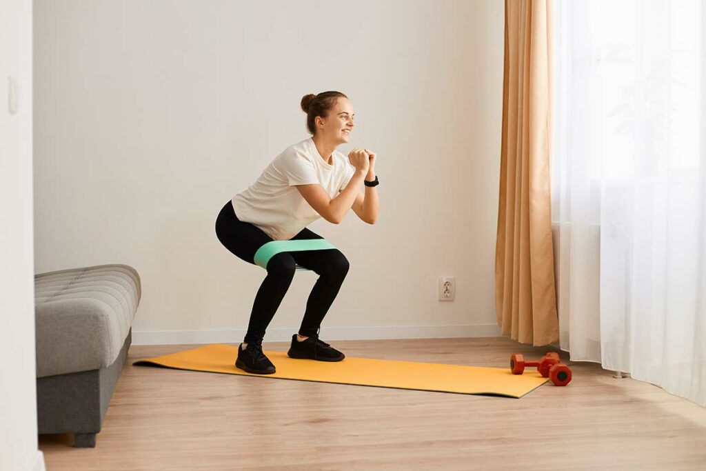 Ragazza che esegue degli squat per rassodare i glutei