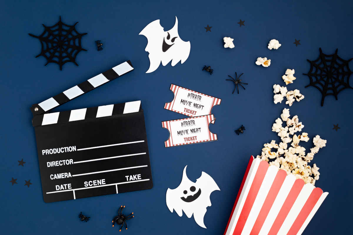 sfondo blu con decorazioni di halloween, ciak di film e popcorn