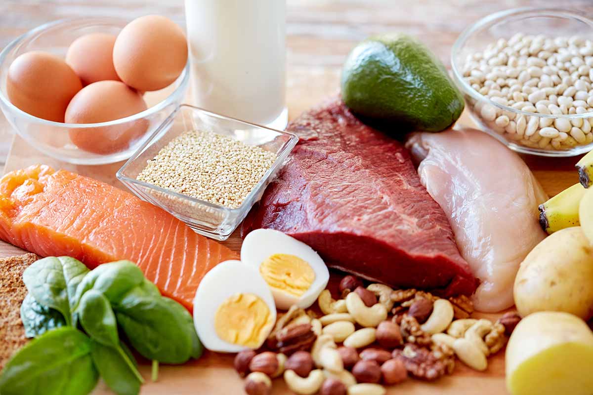Tavola imbandita con pesce, carne, uova e formaggi per una dieta ipocalorica
