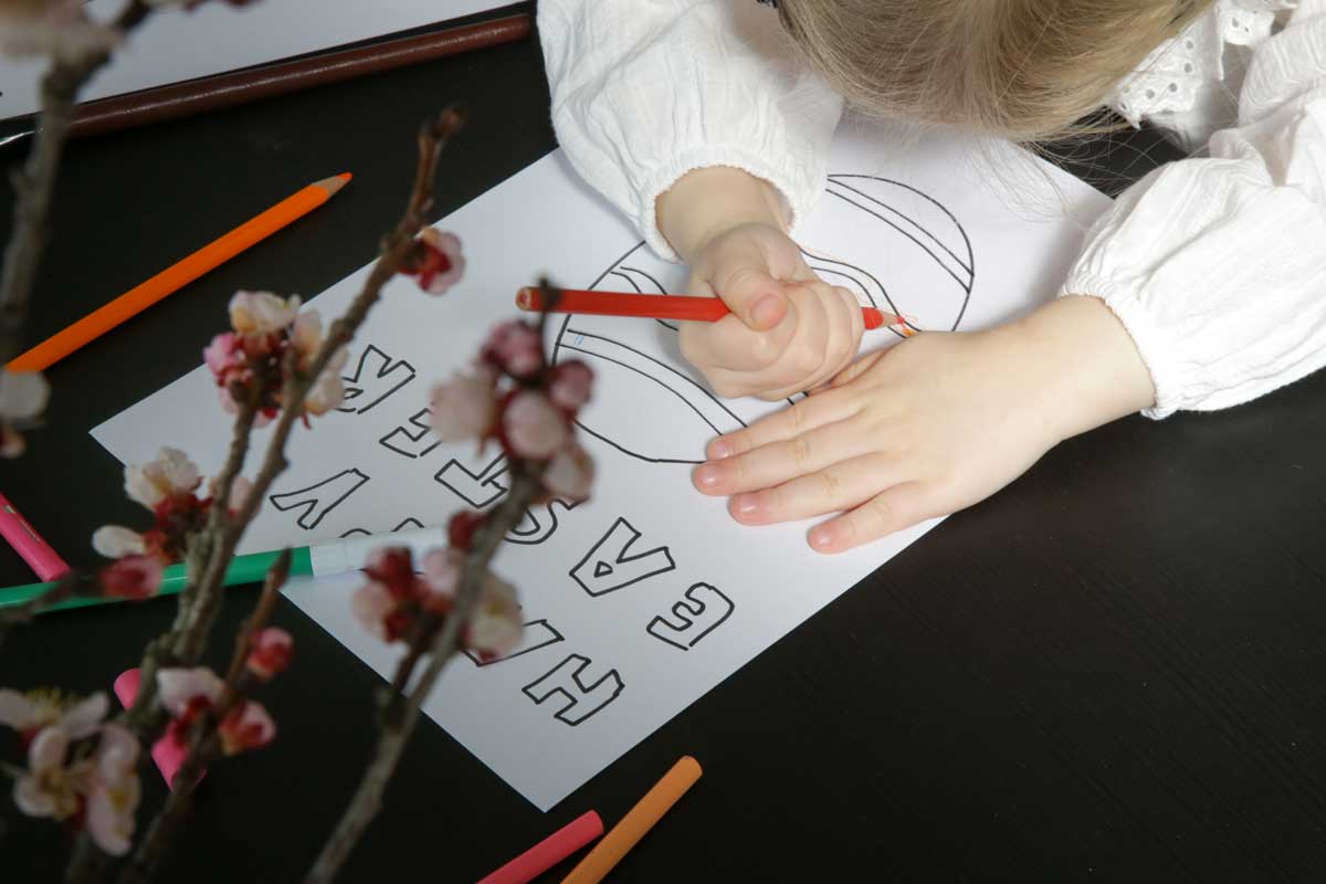 bambina che colora biglietto di pasqua