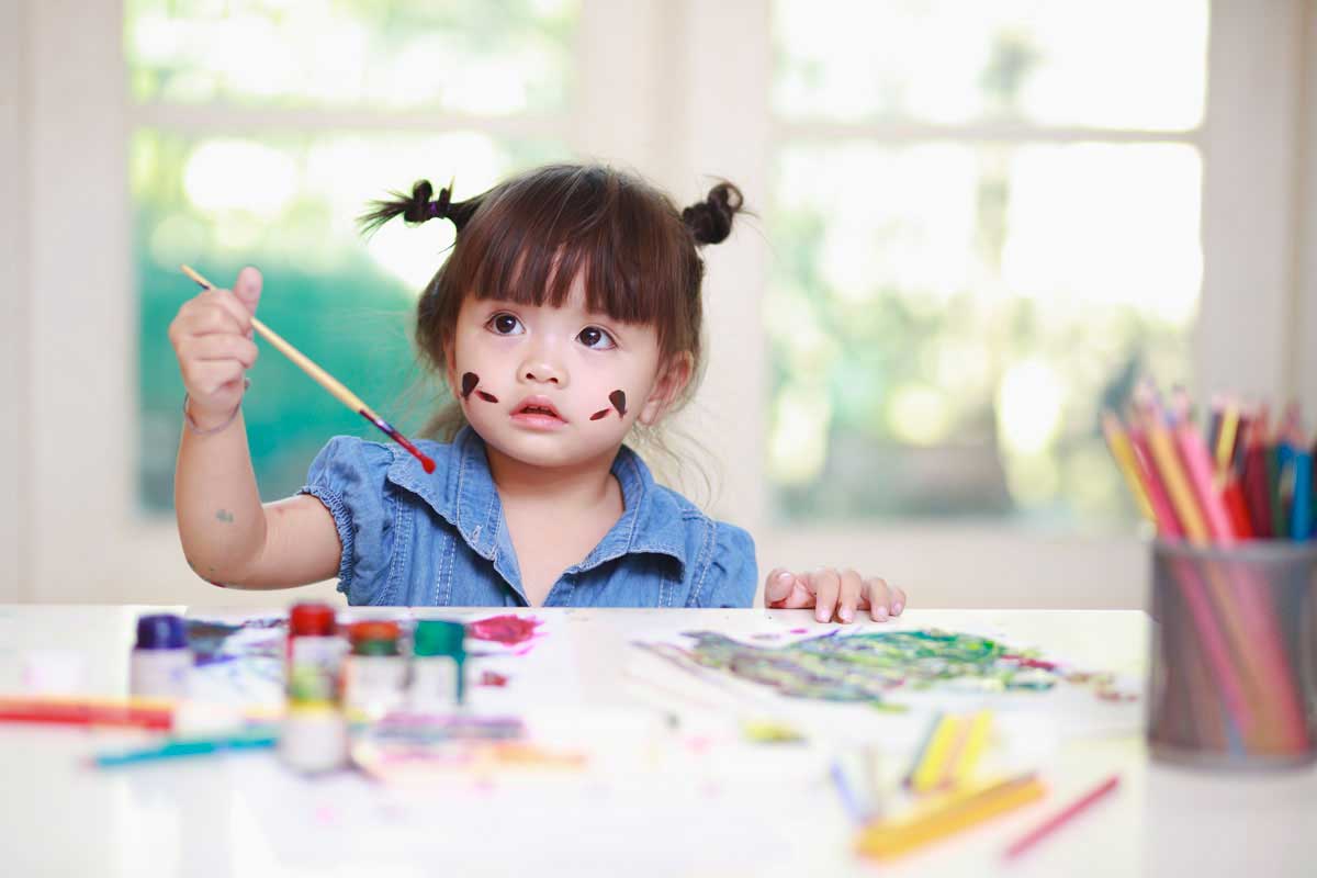 bambina che realizza disegno per la festa della mamma