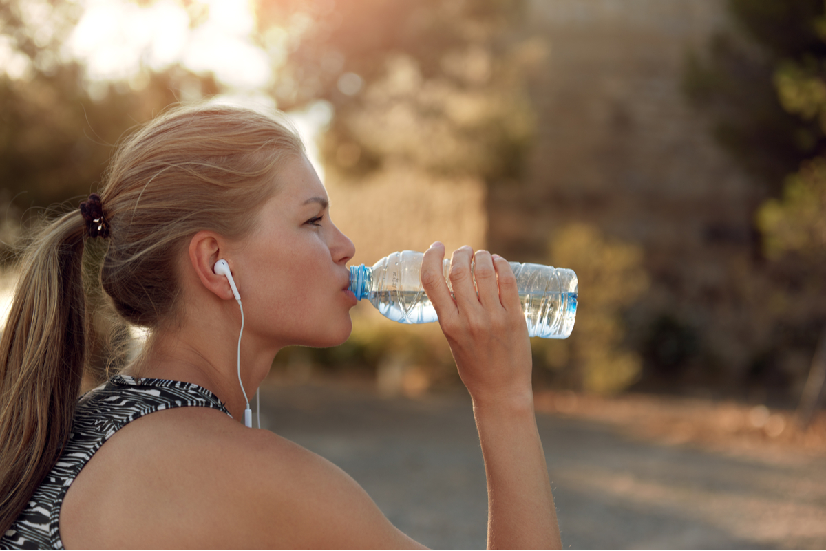 Ragazza che beve acqua durante workout