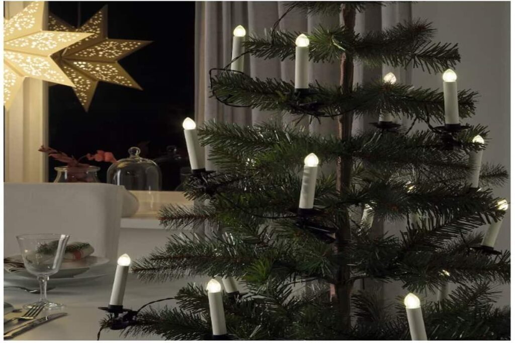 albero di natale di colore verde con luicine a forma di candele 