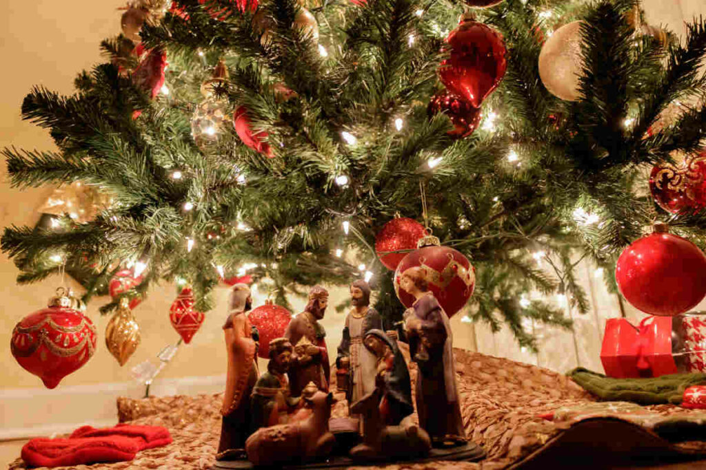 primo piano su presepe con albero di natale in secondo piano