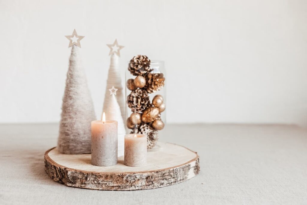 centrotavola natalizio creato con una base in legno, con candele e pigne poggiate sopra