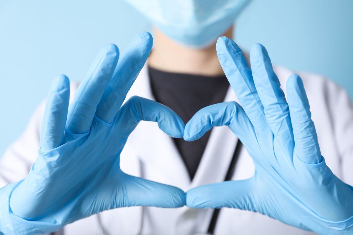 infermiere con mascherina e guanti che forma il cuore con le mani