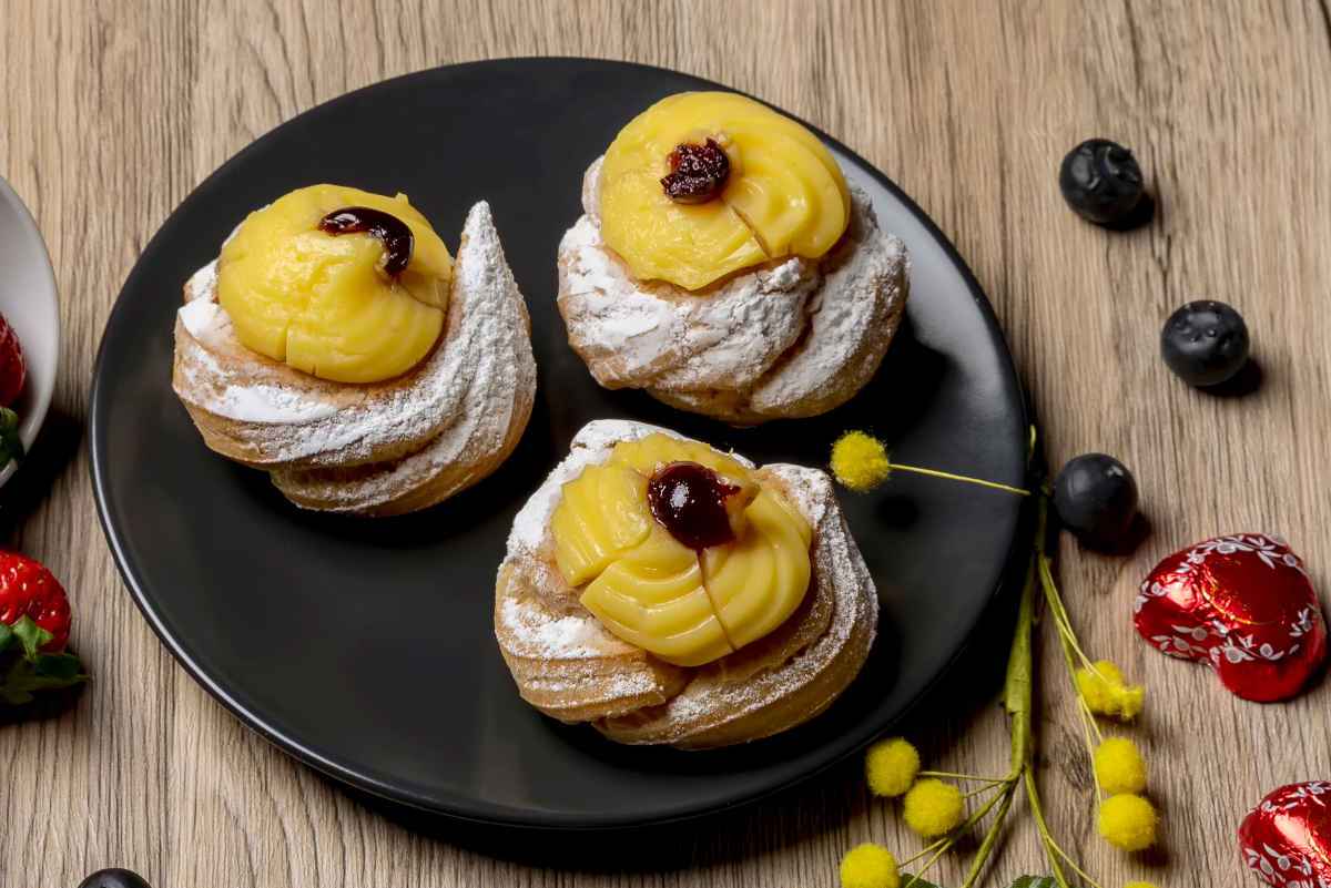 piatto nero con tre zeppole di san giuseppe alla crema