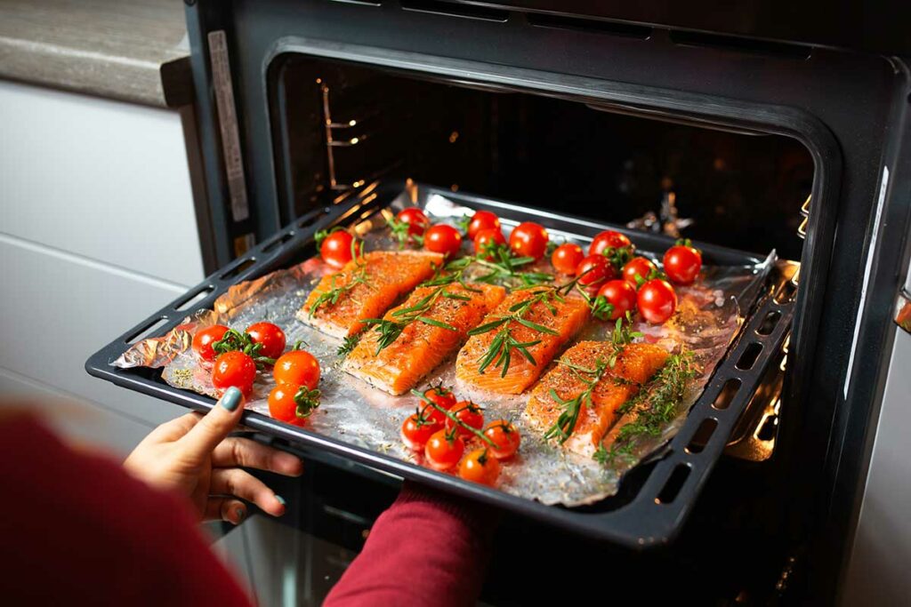 Teglia da forno con all'interno dei filetti di salmone e pomodori pachino