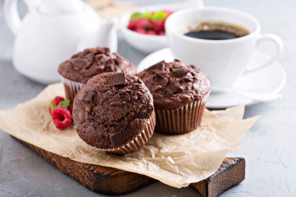 vassoio con tre muffin al cioccolato e una tazza di caffè  per ricette con avanzi delle uova di cioccolato