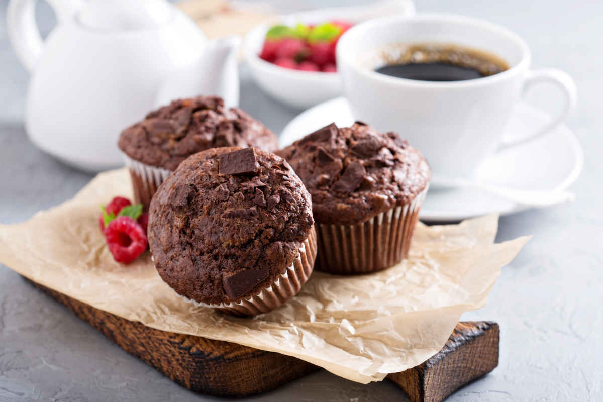 vassoio con tre muffin al cioccolato e una tazza di caffè