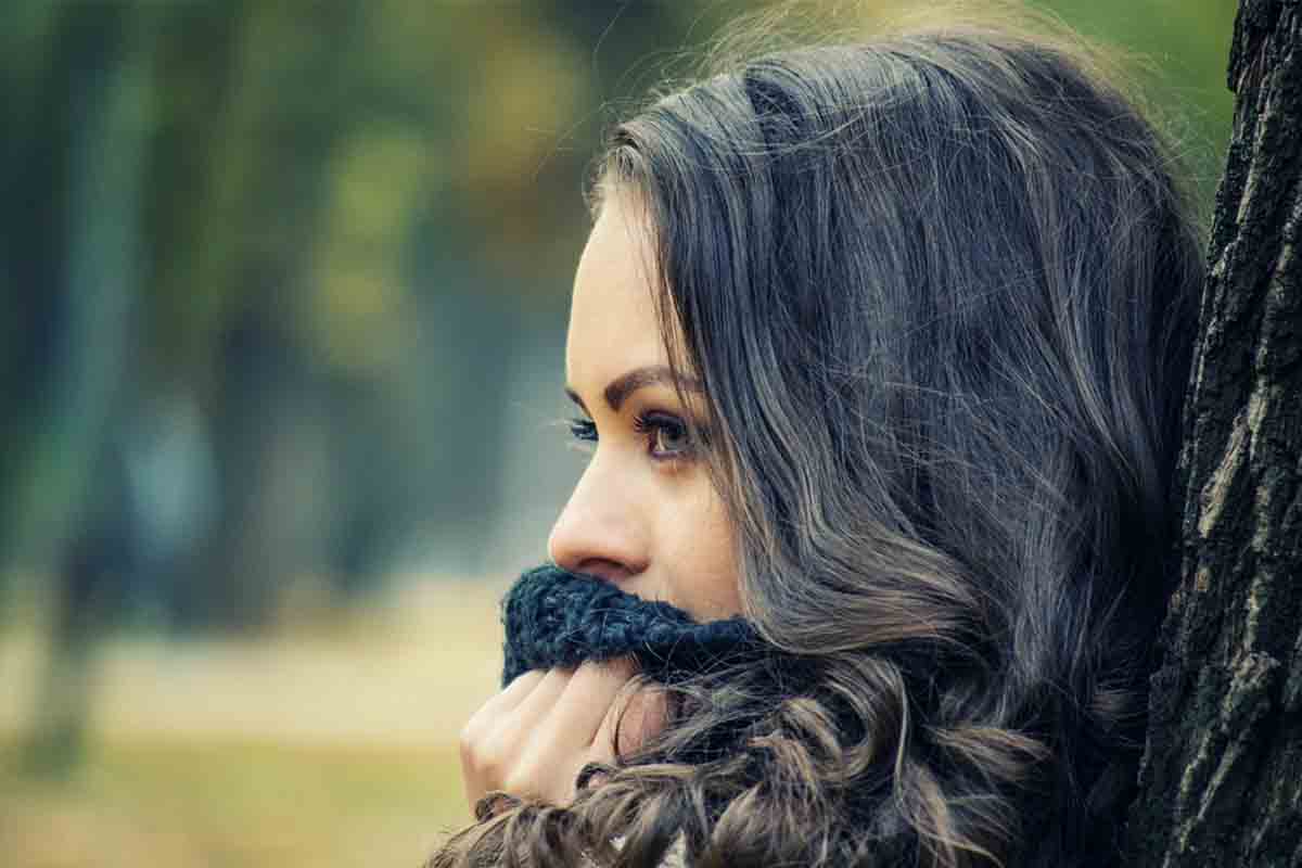 donna appoggiata a un albero