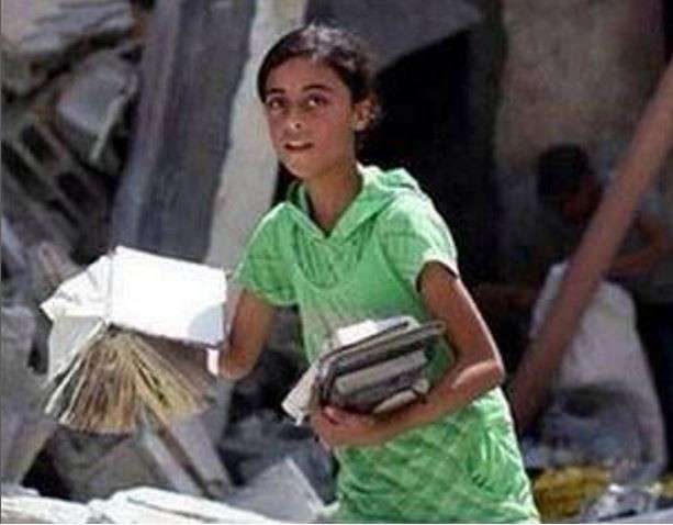 Israele-Palestina: bambina raccoglie libri tra le macerie[FOTO]