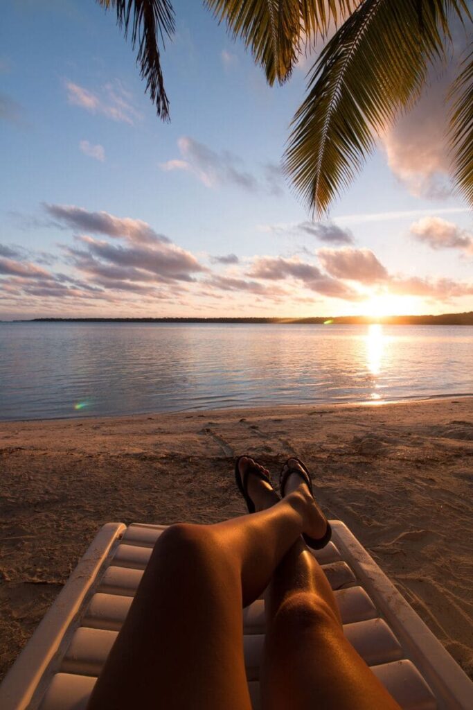 visuale gambe su sdraio con vista tramonto sul mare