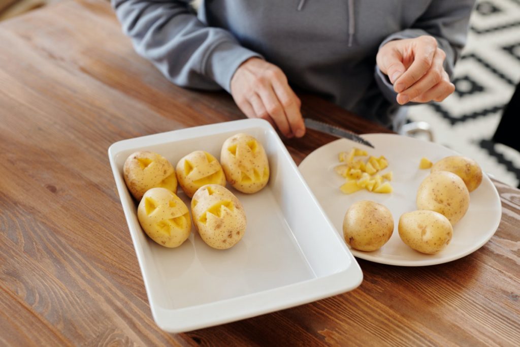 persona che taglia le patate per Halloween