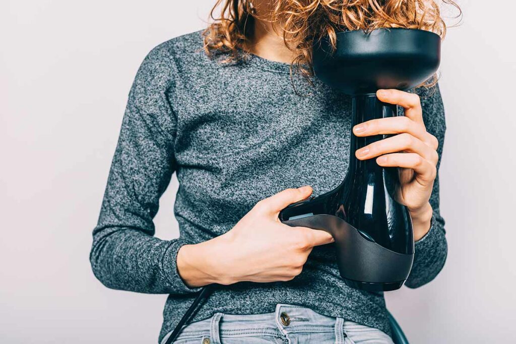 Ragazza che si asciuga i capelli con il diffusore
