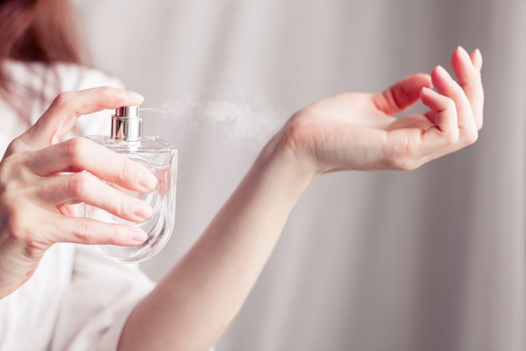 ragazza spruzza profumo sui polsi