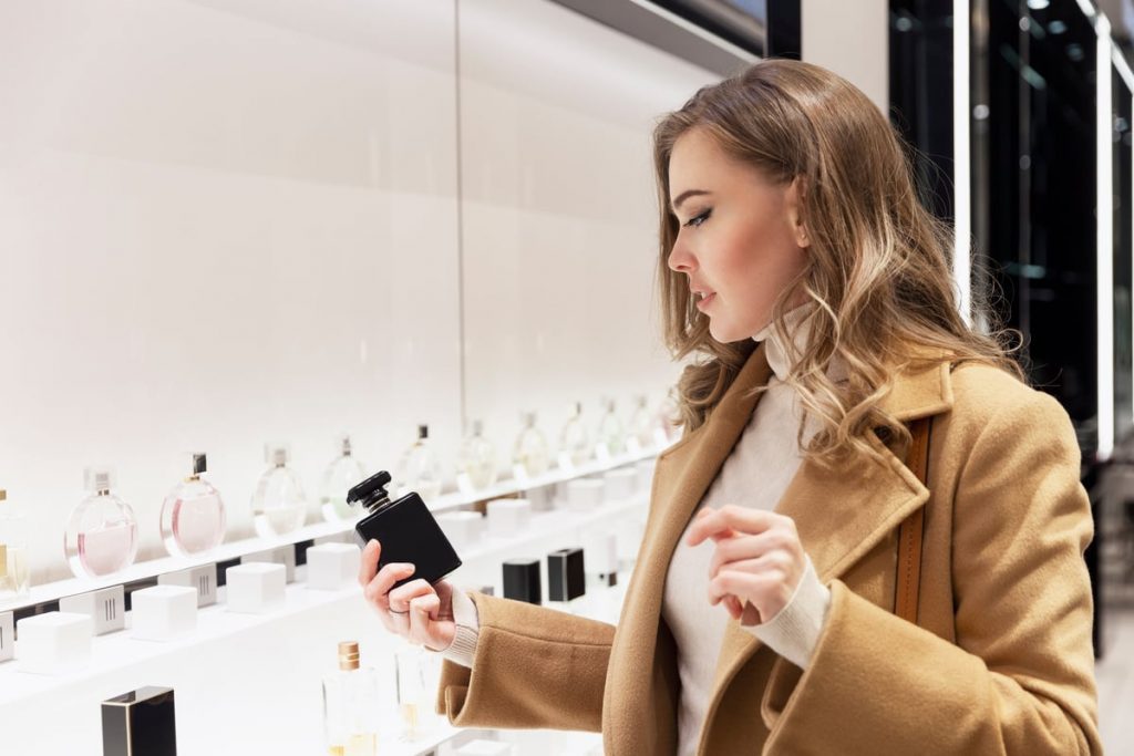 ragazza scegli il profumo in negozio