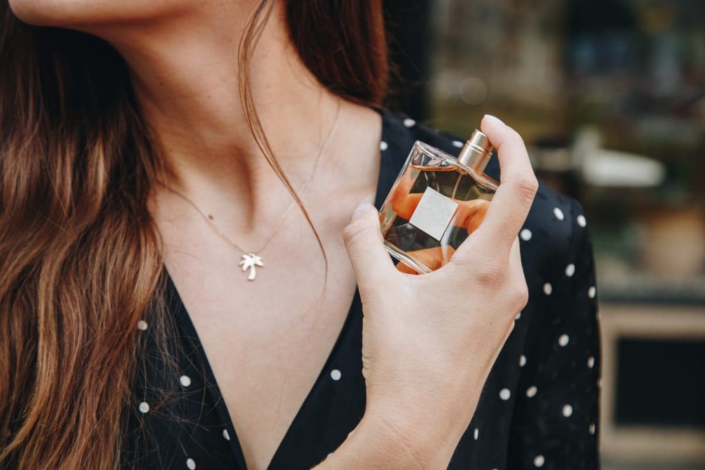ragazza vaporizza il profumo sul collo