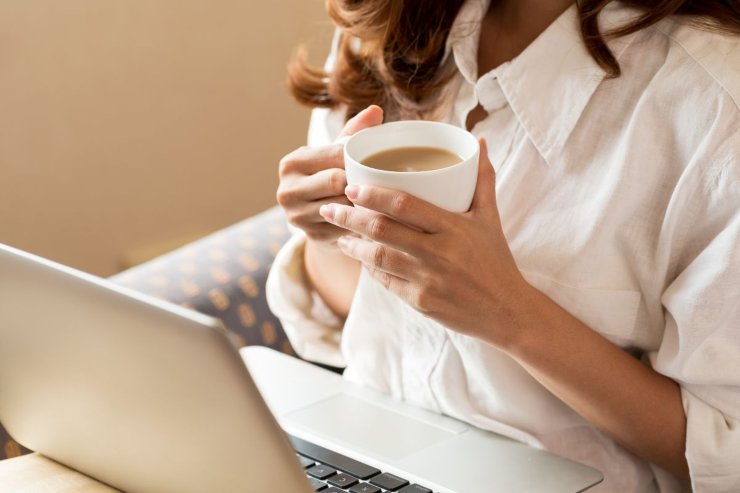 persona che beve caffè davanti al computer
