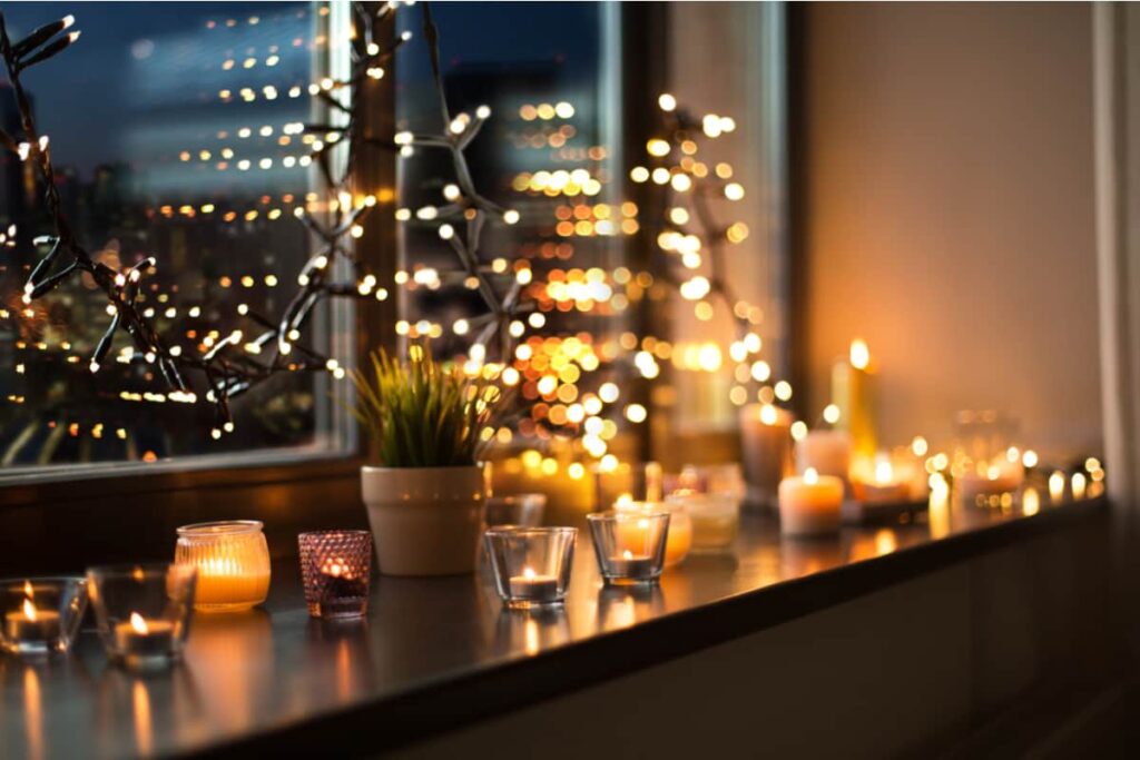 balcone di una finestra con candele e lucine natalizie per la notte di capodanno