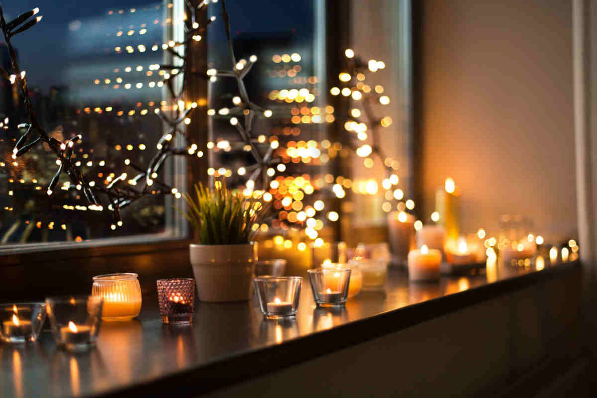 finestra decorata con luci di natale e candele
