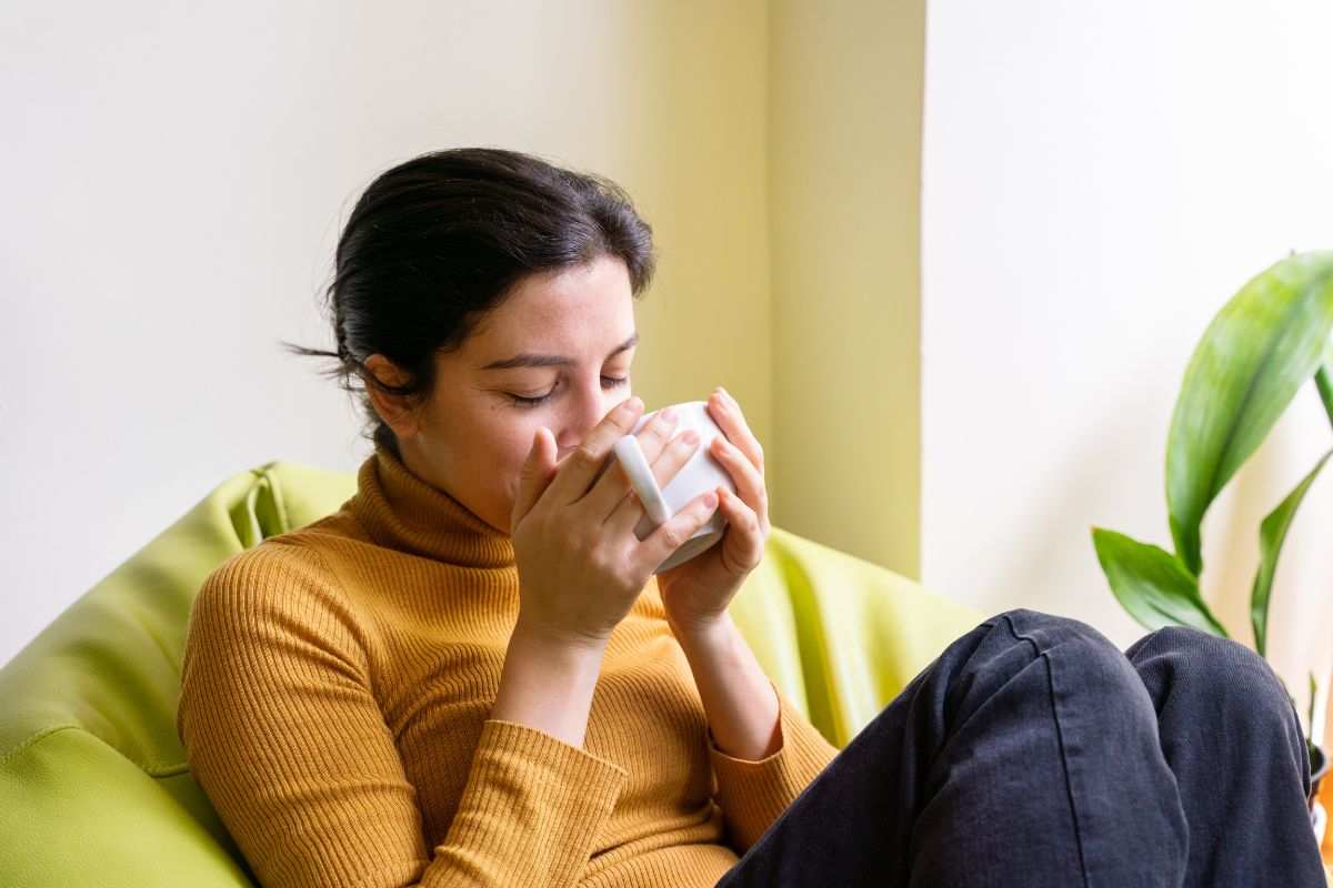 persona seduta che beve una tisana