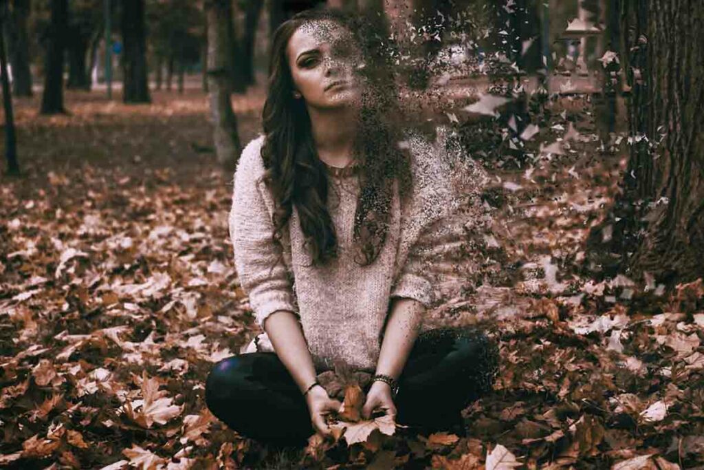 ragazza triste seduta in un bosco