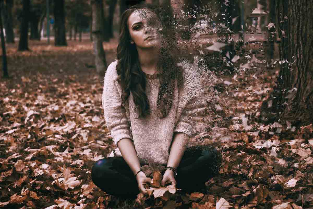 ragazza triste seduta in un bosco