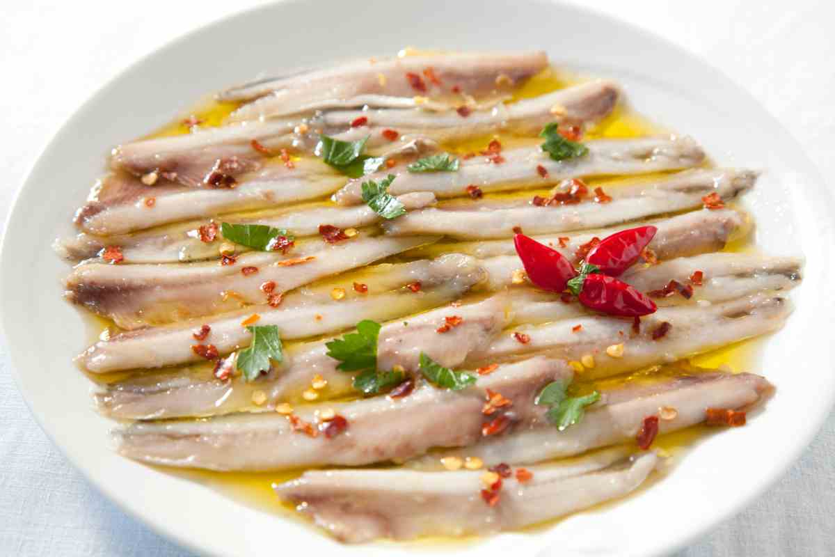 Alici marinate condite con olio e peperoncino in un piatto