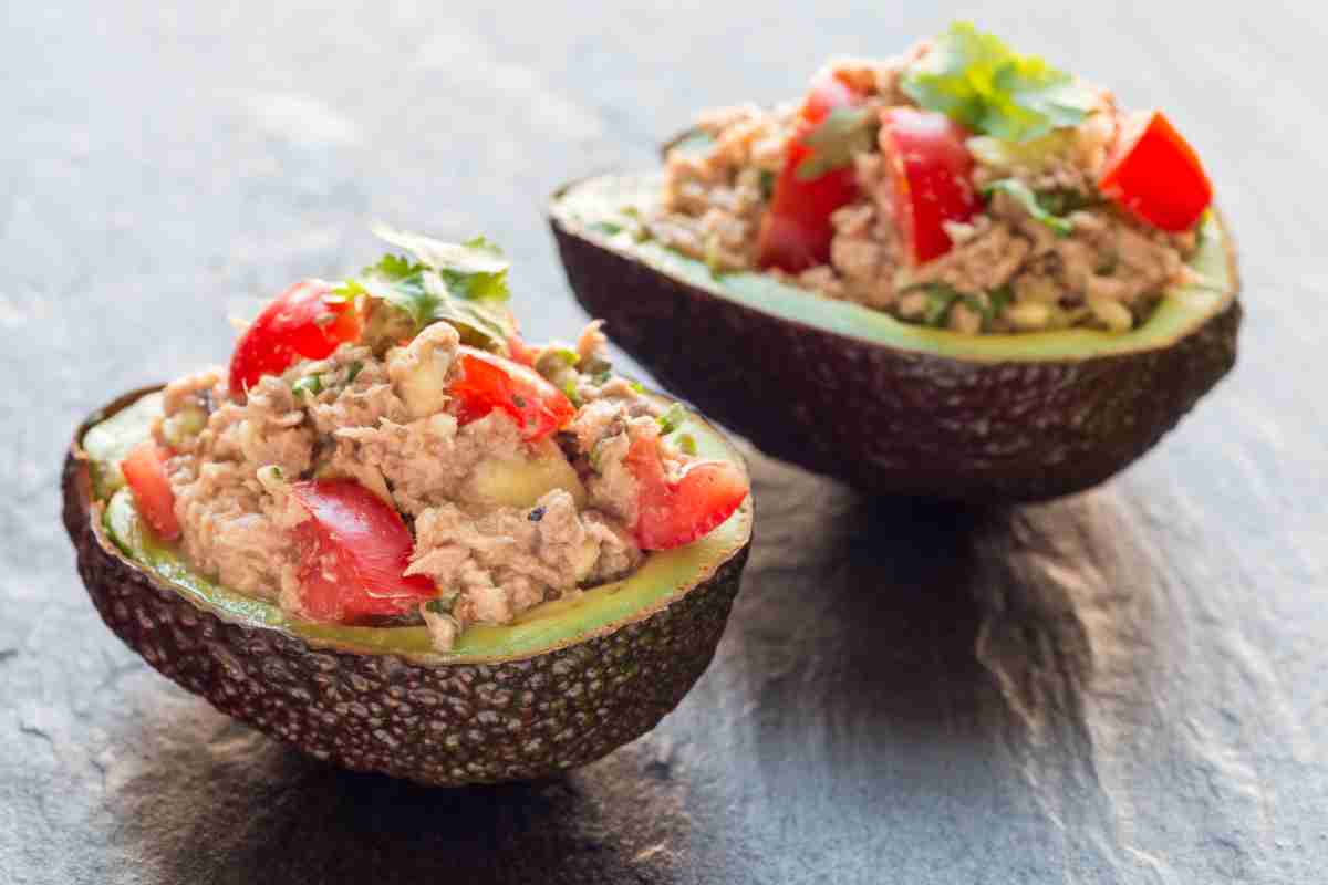 due Avocado ripieni di tonno e pomodorini su un tavolo