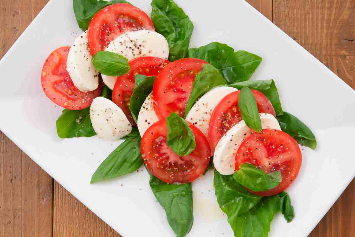piatto con insalata caprese con mozzarella, pomodoro e basilico