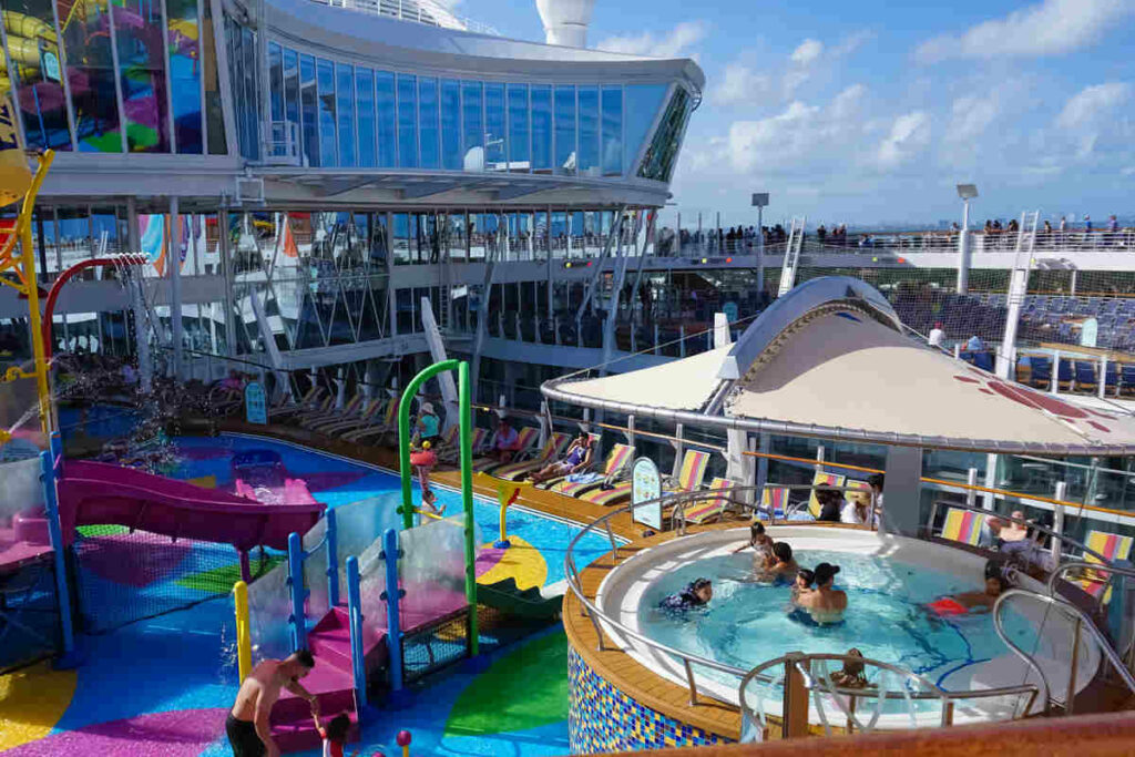 piscine e vasche idromassaggio a bordo di una nave crociera, con persone e bambine che si godono la loro vacanza