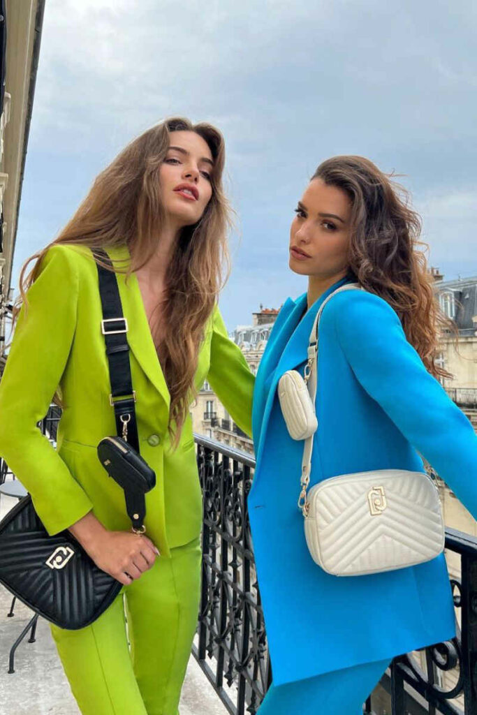 ragazze con completi verde e blu e borse a tracolla