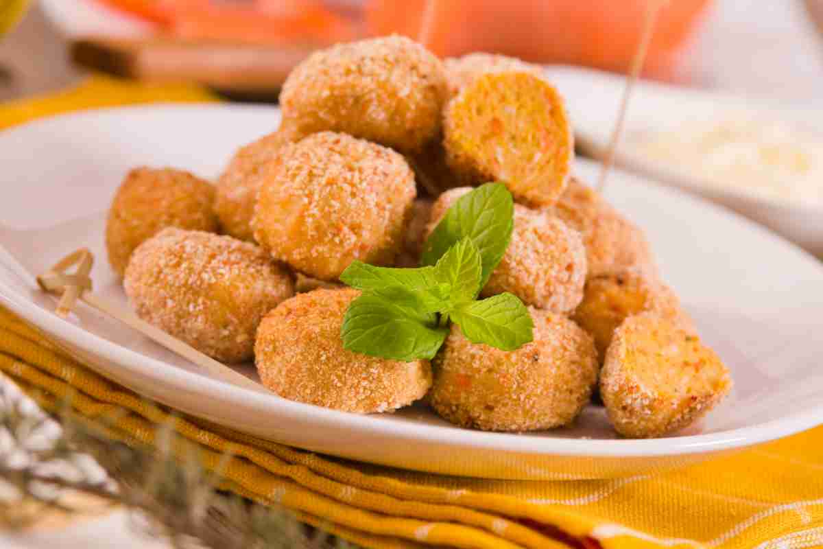 Primo piano di un piatto pieno di polpette di zucca appena fatte