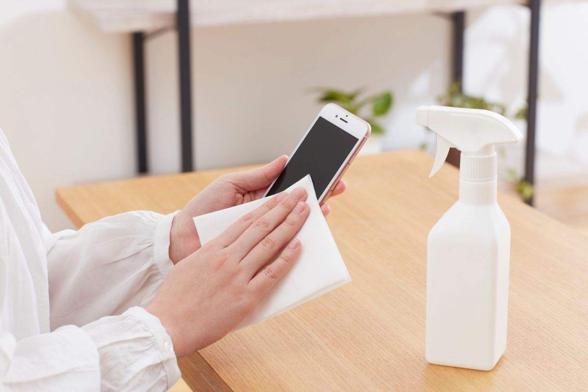 persona che pulisce schermo dello smartphone
