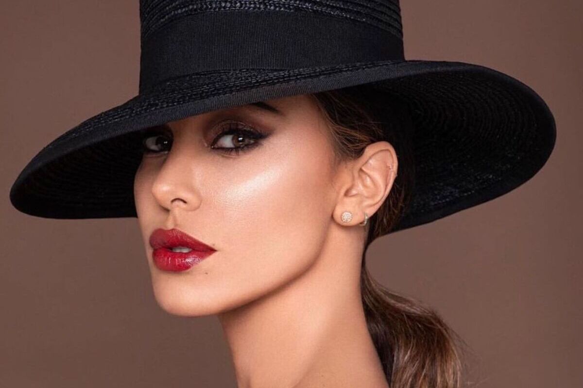Scatto di Belen con cappello scuro a falda larga e rossetto idratante